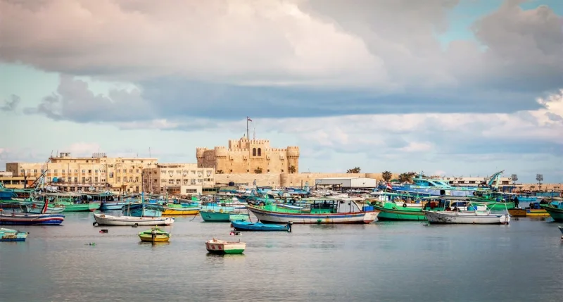 Small boats in front of the Citadel of Qaitbey in Alexandria, Egypt | Day Trip To Alexandria From Cairo | Alexandria Tours Small boats in front of the Citadel of Qaitbey in Alexandria, Egypt | Day Trip To Alexandria From Cairo | Alexandria Tours